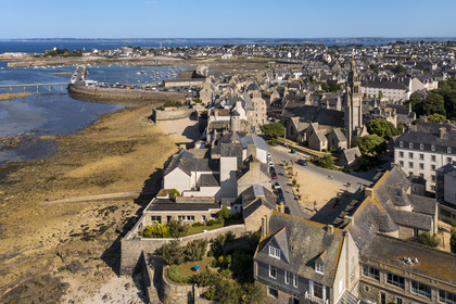 France, Finistère, Roscoff, old shipowners' houses located between rue Amiral Reveillere and the shore, on the right the Notre-Dame de Croaz Batz church and the port in the background (aerial view)