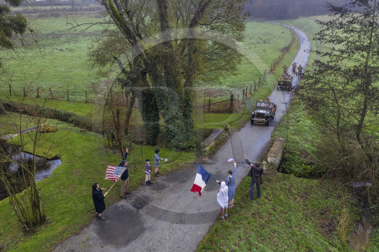 France, Eure (27), Sainte-Colombe-prés-Vernon, Allied Reconstitution Group (association de reconstitution historique de la 2éme Guerre Mondiale américain et Maquis), reconstitueurs en uniforme de la 101e division aéroportée US progressant en jeep Willys accueillis en libérateurs par des villageois et FFI (vue aérienne)