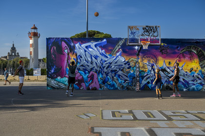 France, Charente Maritime, La Rochelle, the Old Port lighthouse the red lantern in the Gabut district and street art on the basketball court
