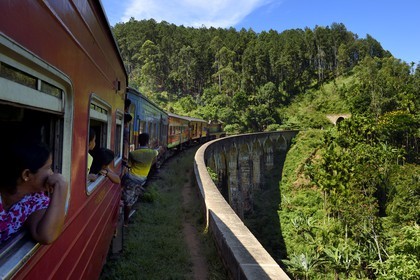 Sri Lanka, Province d'Uva, train sur la voie de chemin de fer dans la région montagneuse de la culture du thé entre Badulla et Ella, le Pont aux Neuf Arches non loin de Ella, passagers accrochés aux portières