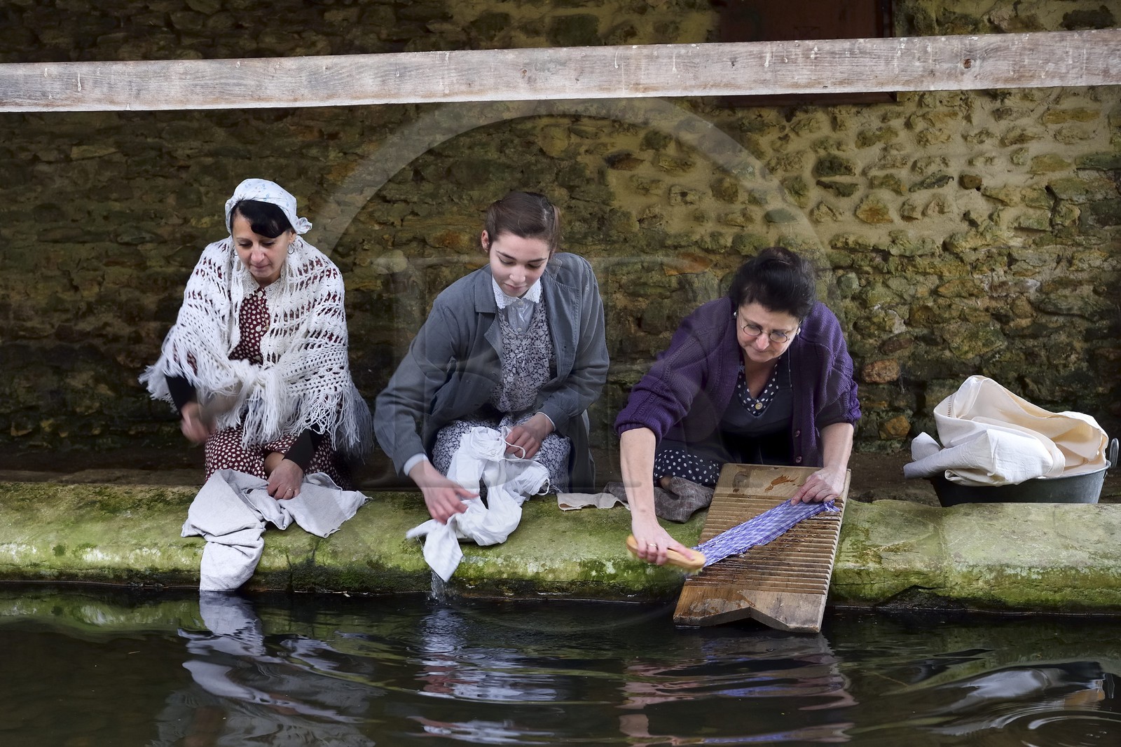 France, Eure (27), lavoir de Sainte-Colombe-prés-Vernon, Allied Reconstitution Group (association de reconstitution historique de la 2éme Guerre Mondiale US et Maquis), les reconstitueurs montrant trois femmes lavant de linge au lavoir dans les années 1940