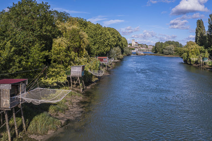 France, Charente-Maritime, Saintonge, Saint-Savinien, labeled stones and water villages, fishing huts with a net along the Charente river  and the village in the background (aerial view)