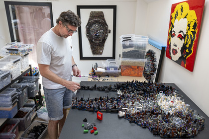 France, Cote d'Or, Dijon, Artist Aymeric Gillet, aka M'Brick, in his studio filled with crates of multicolored Lego used to create giant pixelated paintings inspired by pop culture
