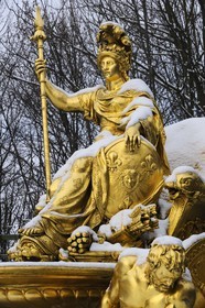 France, Yvelines, snow covered park of the Chateau de Versailles, listed as World Heritage by UNESCO, detail of a statue of the Triumphal Arch Grove