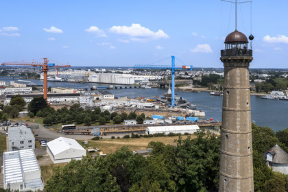 Morbihan (56), Lorient, l’Enclos du port, La tour de la découverte, la boule horaire donne chaque jour l’heure solaire de midi en chutant, et les installations de Naval Group en arrière plan (vue aérienne)