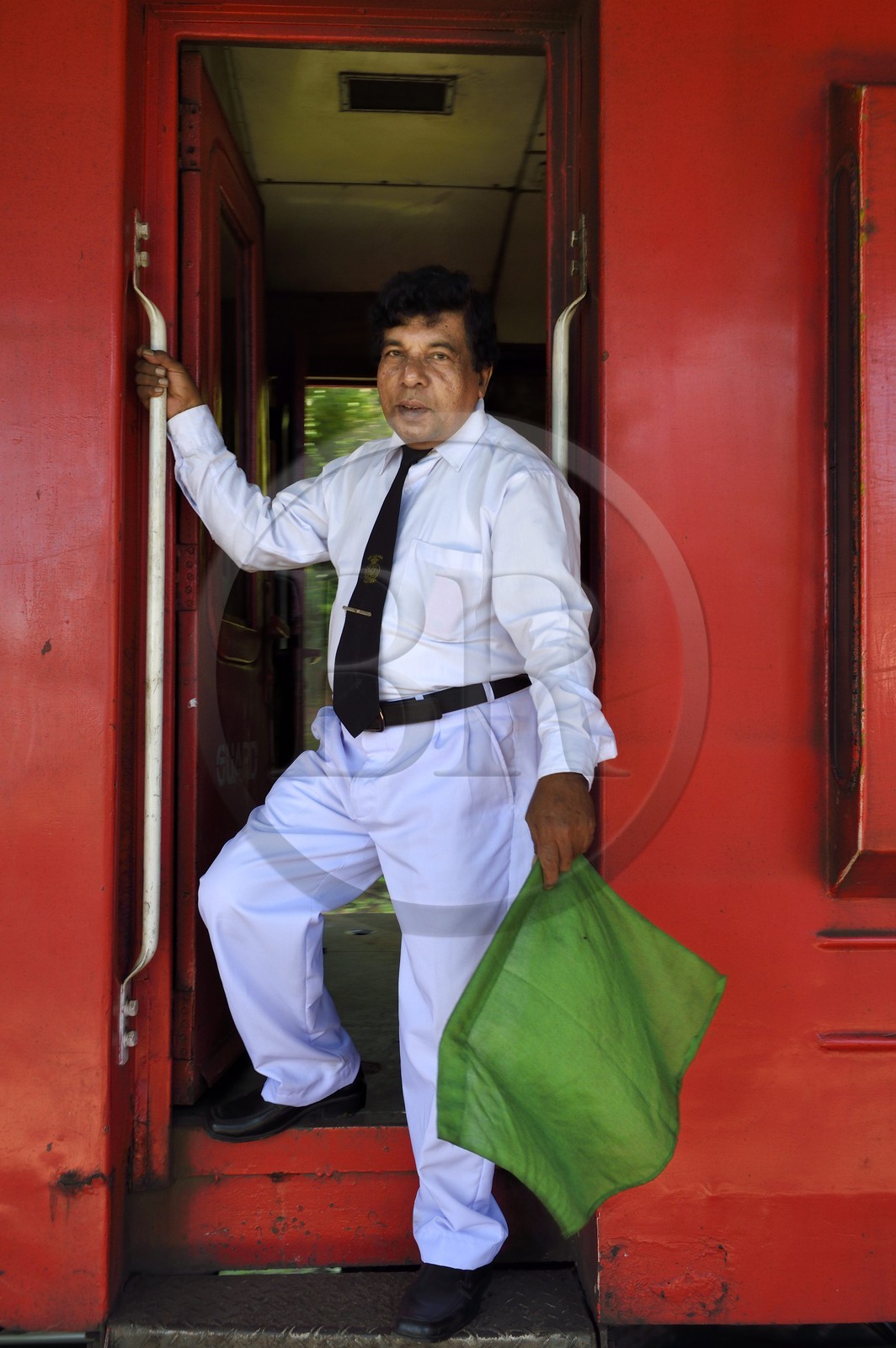 Sri Lanka, Province d'Uva, trajet en train dans la région montagneuse de la culture du thé entre Badulla et Ella, chef de train avec son fanion vert donnant le signal de départ