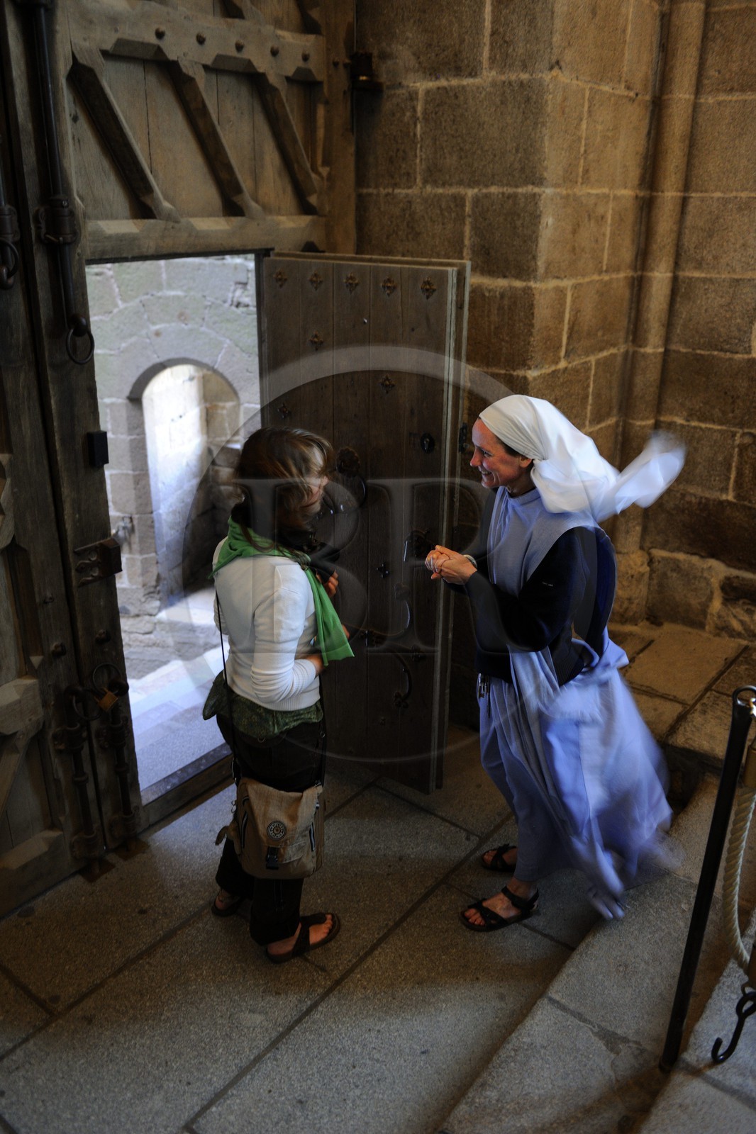 France, Manche (50), l'abbaye du Mont-Saint-Michel, classé Patrimoine Mondial de l'UNESCO, soeur des Fraternités Monastiques de Jérusalem acceuillant des fidèles pour les vêpres à la Porterie ou salle des Gardes