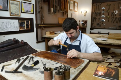 Argentine, province de Buenos Aires, San Antonio de Areco, atelier du maroquinier Martin Alvarez qui martèle le cuir d'un élément d'une selle