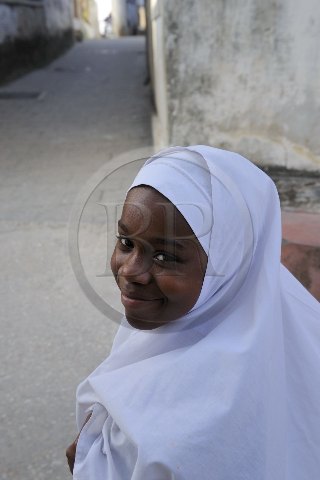 Tanzanie, archipel de Zanzibar, île de Unguja (Zanzibar), ville de Zanzibar, quartier Stone Town, classé Patrimoine Mondial de l' UNESCO, jeune fille voilée au retour de l'école dans une ruelle de la vieille ville dans le quartier de Shangani