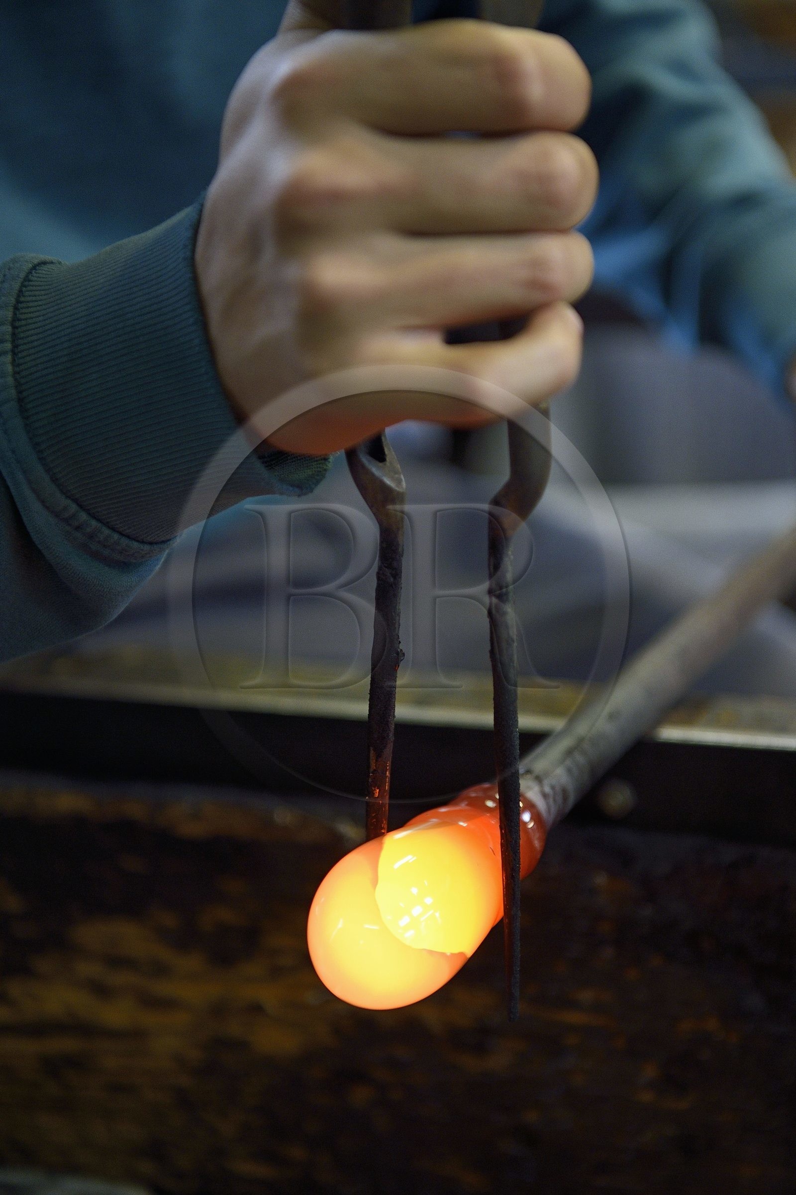 France, Moselle (57), Meisenthal, Centre international d’Art verrier (CIAV), l'atelier de soufflage, fabrication artisanale d'une boule de Noël, le souffleur régularise la masse au marbre tout en effectuant une rotation continue de sa canne
