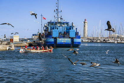 France, Hérault (34), Sète, Port de pêche, barque de l'association Occitarame qui milite pour une pratique de la rame traditionnelle, le phare du mole Saint-Louis en arrière-plan