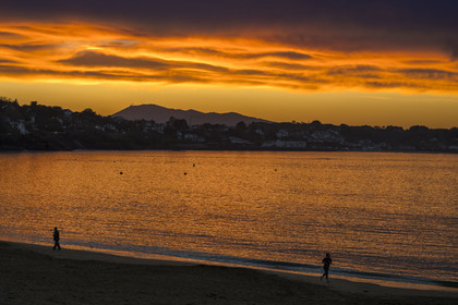 France, Pyrenees Atlantiques, Basque Country, Saint Jean de Luz, walkers on the Grande Plage, the coast of Ciboure in the bay and the Spanish mount Jaizkibel in the background