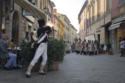 Italy, Liguria, Sarzana, Napoleon Festival, french soldier of the Grande Armée firing at the austrian enemy in the main street Via Mazzini in the old town