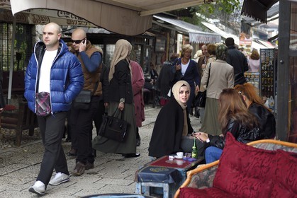 Bosnia and Herzegovina, Sarajevo, Bascarsija district in the old town, Bravadziluk street famous for its Burek and cevapi restaurants, veiled and unveiled girls sitting together at an outdoor cafe