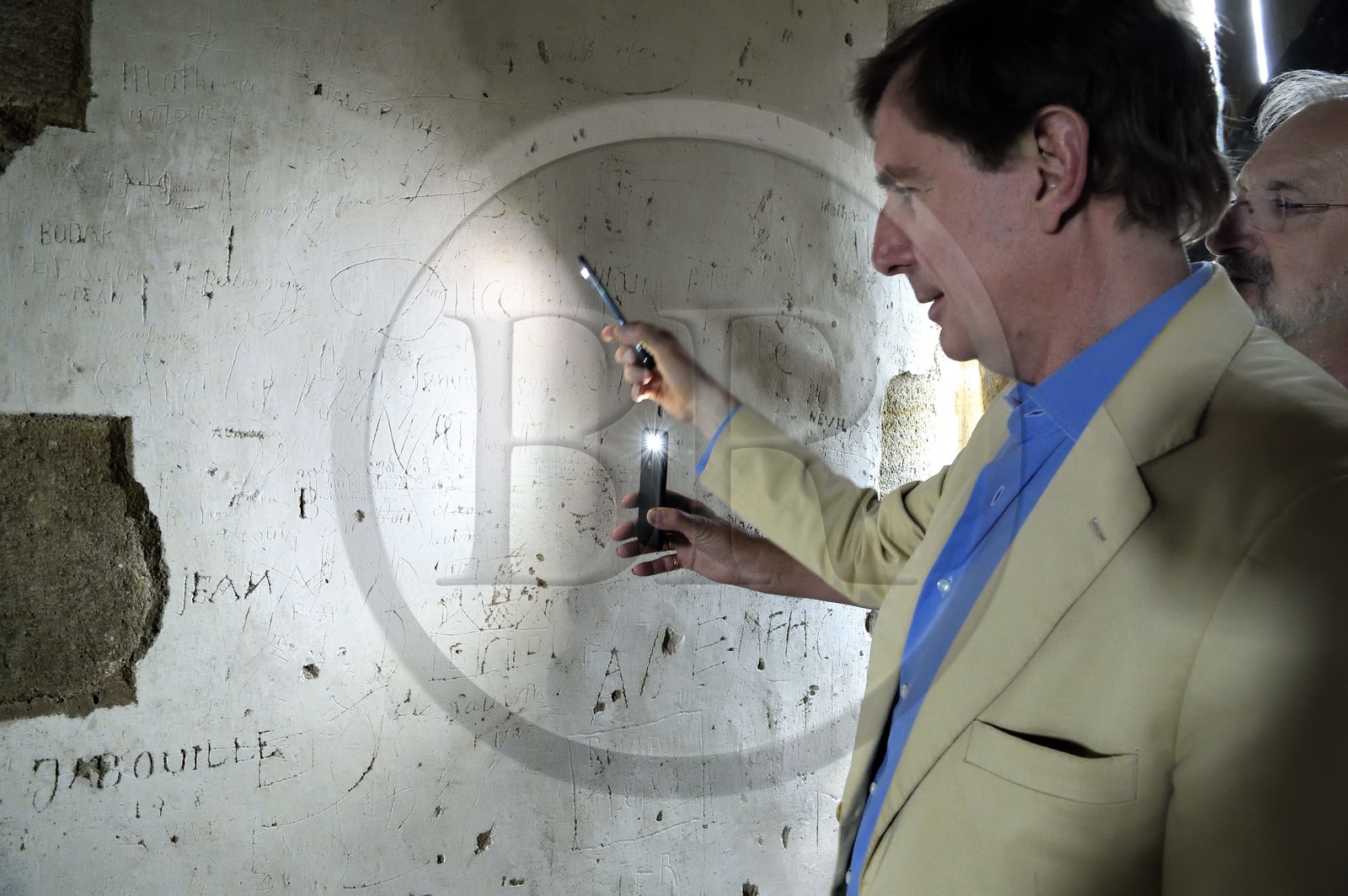 France, Allier (03), ancienne province du Bourbonnais, Besson, chateau de Fourchaud (XIVe siècle au XVIe siècle) appartenant aujourd'hui aux descendants des Bourbon-Parme, le Prince Charles Henri de Lobkowicz observant des graffitis au deuxième étage dont celui du sieur Porcheron qui a représenté la ville d’Angoulême et daté de 1753