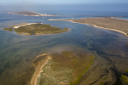 Portugal, Algarve, Ria Formosa Natural Park, Faro, Island of Barreta or Deserta (Ilha da Barretta or Deserta), the lighthouse of Ilha do Farol part of  Ilha da Culatra in the background (aerial view)