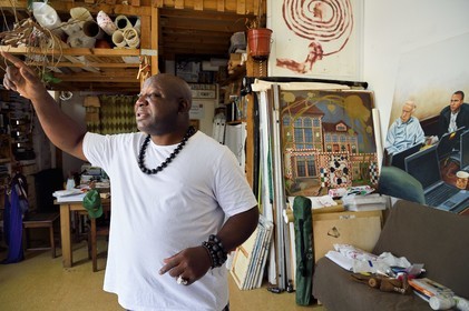 France, Paris, Barthelemy Toguo, the artist founder of Bandjoun Station in Cameroon (shown in the painting in the background), in his Parisian studio