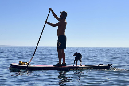 Portugal, Algarve, Lagos, stand up paddle boarding at the foot of the steep cliffs of Ponta da Piedade