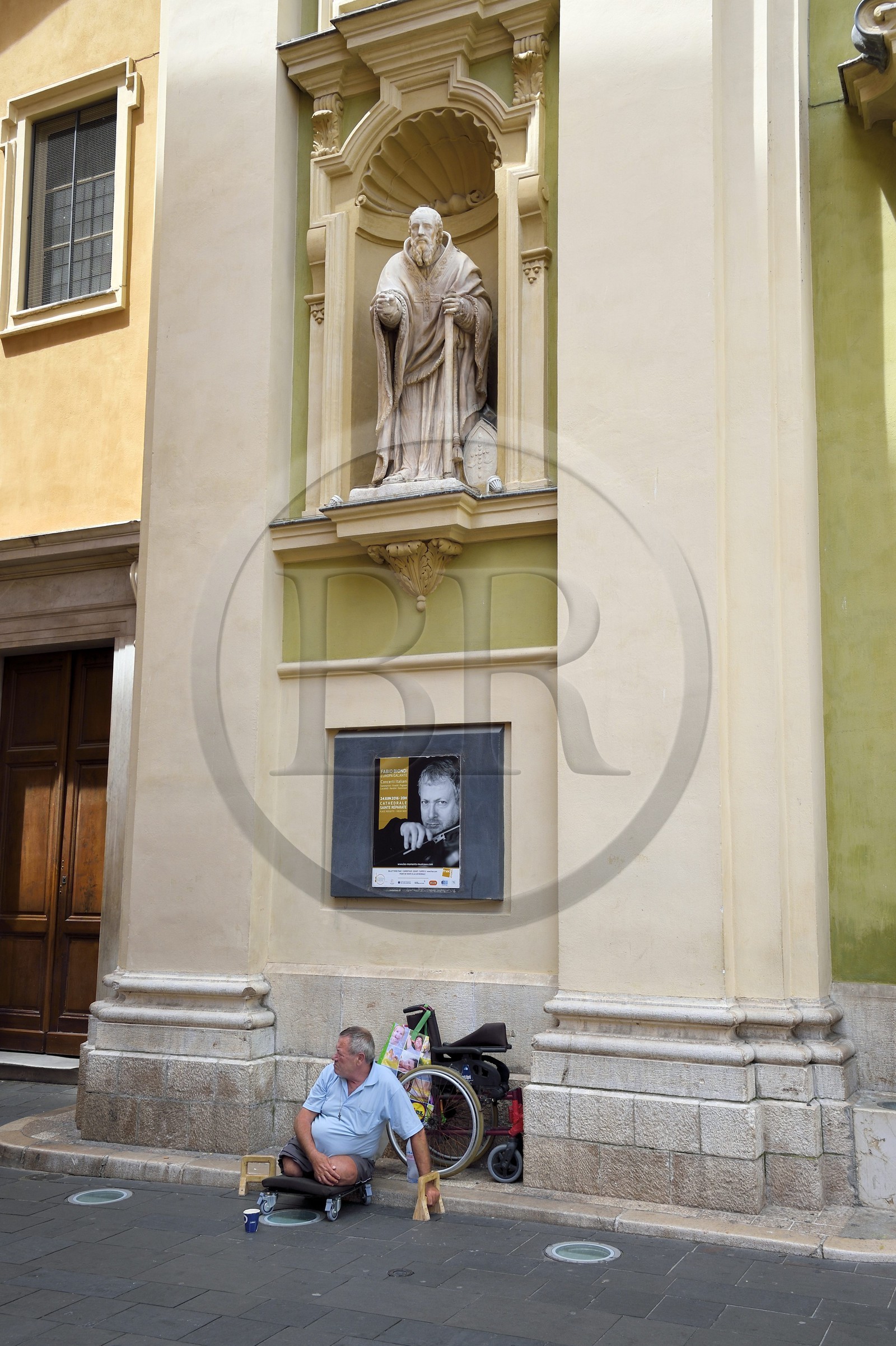 France, Alpes-Maritimes (06), Nice, quartier du Vieux Nice, mendiant devant la Cathédrale Sainte-Réparate et sous la statue de Saint Bassus France, Alpes-Maritimes (06), Nice, quartier du Vieux Nice, mendiant devant la Cathédrale Sainte-Réparate et sous la statue de Saint Bassus