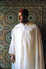 Morocco, Middle Atlas, Fez, Imperial City, Sofitel Palais Jamai Hotel doorman with a jilbab in front of the zelliges