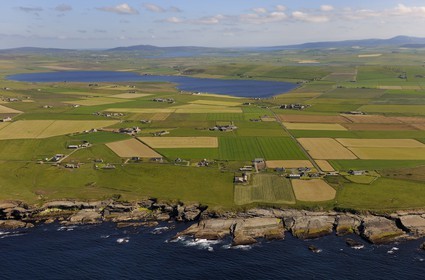 Royaume-Uni, Ecosse, Iles Orcades, Ile de Mainland, champs et fermes éparses en bordure de mer à Birsay, le Loch of Boardhouse en arrière plan (vue aérienne)