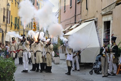 Italy, Liguria, Sarzana, Piazza Matteotti, Napoleon Festival, austrian soldiers firing at the french enemy in the main street Via Mazzini in the old town