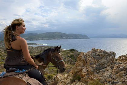 France, Haute Corse, Nebbio, Agriates Desert, Peraiola Cove, rider on the North-East of Ostriconi beach on the Punta di l’Acciolu (Acciola)
