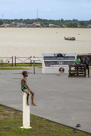 France, Guyane, Saint-Laurent-du-Maroni, berges réaménagées du quartier de La Charbonnière aux racines bushinenguées et bateau sur le fleuve Maroni, frontière naturelle avec le Suriname en arrière plan