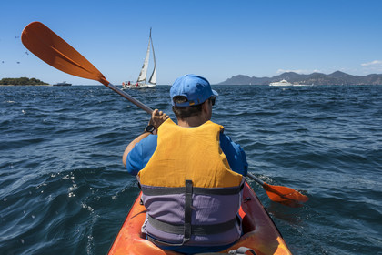 France, Alpes-Maritimes, Cannes, kayaking in the Lerins Islands, passage between Cap de la Croisette and Ile Sainte-Marguerite in the background left, the Esterel mountains on the right