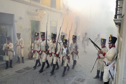 Italy, Liguria, Sarzana, Piazza Matteotti, Napoleon Festival, austrian soldiers firing at the french enemy in the main street Via Mazzini in the old town