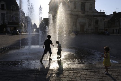 France, Indre et Loire, city of Richelieu, market square, children playing in the water of the fontain