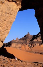 Libya, region of the desert, the Fezzan (Sahara), Tadrart Akacus, Tuareg under the arch (in sandstone) of Afazedjar