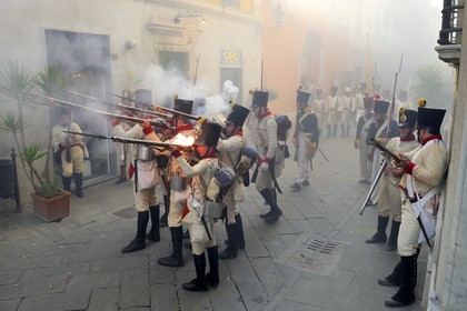 Italy, Liguria, Sarzana, Piazza Matteotti, Napoleon Festival, austrian soldiers firing at the french enemy in the main street Via Mazzini in the old town