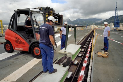 France, Var (83), Toulon, la base navale (Arsenal), le porte-avions à propulsion nucléaire Charles de Gaulle en rénovation de mi-vie, le pont d'envol, des ouvriers de l'entreprise Naval retirent les panneaux de fosse de la catapulte avant