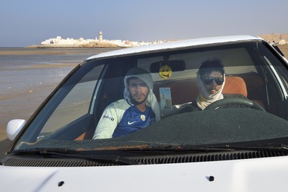 Sultanate of Oman, Ash Sharqiyah South Governorate, city and harbour of Sur, young omani in car on the beach