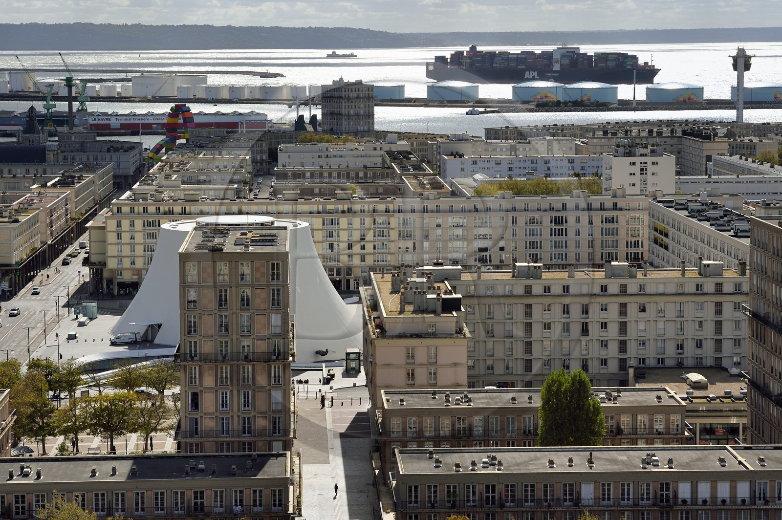 France, Seine-Maritime (76), Le Havre, Centre-ville reconstruit du Havre par Auguste Perret classé Patrimoine Mondial de l'UNESCO, immeubles Perret autour du Volcan réalisé par Oscar Niemeyer, un porte-conteneurs en arrière plan sort du port de commerce