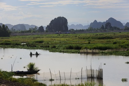 Vietnam, province de Ninh Binh, pêcheurs sur un canal et montagnes karstiques