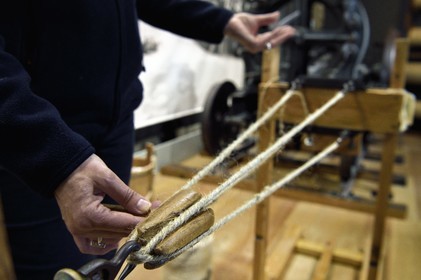 France, Charente-Maritime (17), Rochefort, Centre International de la mer dans l'ancien Arsenal maritime de Rochefort, la Corderie Royale conçue par Colbert en 1666, démonstration du métier de cordier, le toronnage guidé par un toupin qui permet de fabriquer la corde à partir de fils