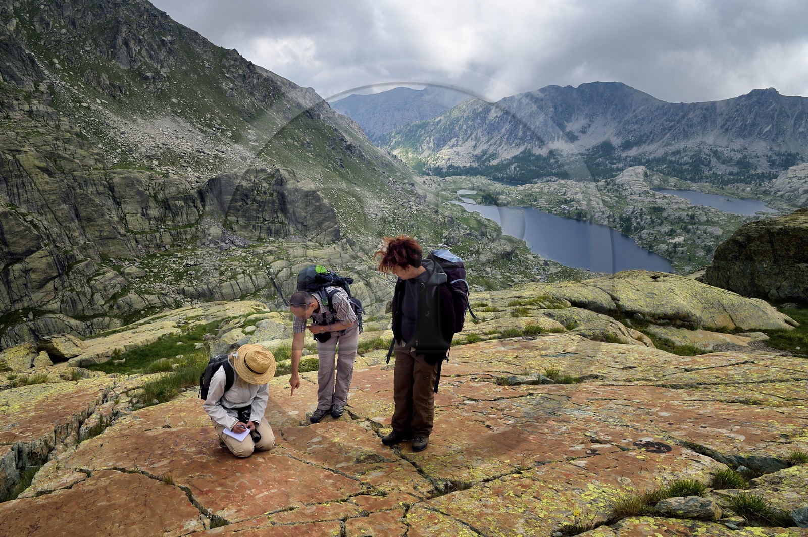 France, Alpes-Maritimes (06), parc national du Mercantour, Vallée des Merveilles parsemée de milliers de gravures rupestres de l'Age de bronze, dalles de schiste jaune des chiappes, observation de figures corniformes en compagnie de l'archéologue Nicoletta Bianchi