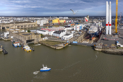 France, Loire-Atlantique (44), Saint-Nazaire, l'ancienne base sous-marine allemande et l'écluse fortifiée construites lors de la dernière guerre mondiale à gauche et chantier du super-yacht de luxe Ritz-Carlton Luminara dans la forme Joubert à droite, les tours d'éoliennes sont stockées avant embarquement (vue aérienne)