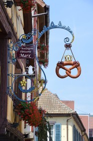France, Haut Rhin, Eguisheim, labelled Les Plus Beaux Villages de France (The Most Beautiful Villages of France), emblem of a baker shaped pretzels sign