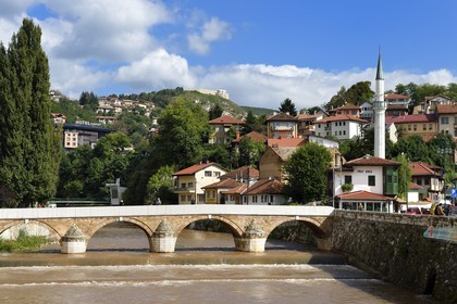 Bosnia and Herzegovina, Sarajevo, the Seher Cehaja bridge over the Miljacka River and the House of Spite (Inat Kuca) on the right underneath the minaret