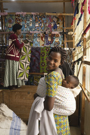 Rwanda, Province du Nord, Musanze (anciennement nommée Ruhengeri), centre commercial Goico plaza, le couturière Joseline avec son bébé Elouange de 7 mois et sa tante en arrière plan qui vend les tissus