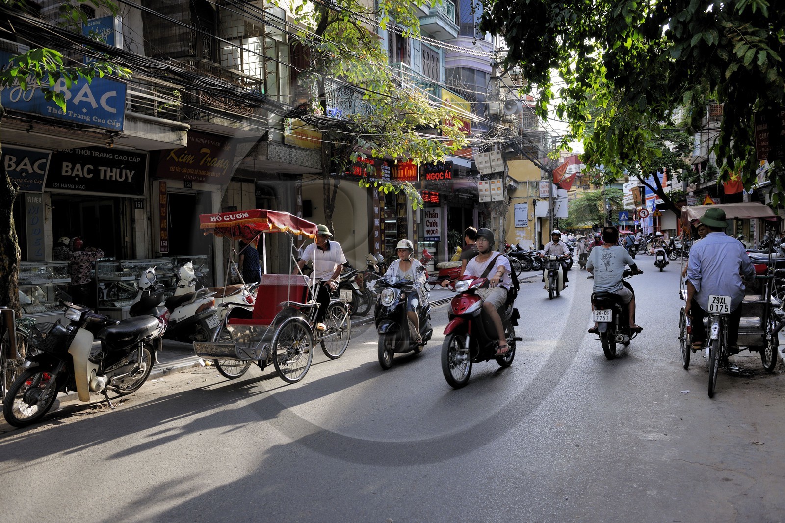 Vietnam, Hanoï, circulation de motos et cyclo pousses dans la vieille ville