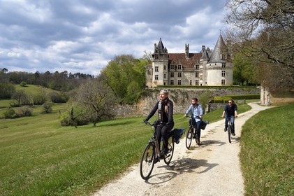 France, Dordogne, Périgord Vert, Villars, cyclists traveling along the Flow Vélo cycle route in front of Renaissance style Puyguilhem castle