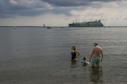 France, Loire-Atlantique (44), Estuaire de la Loire, Saint-Nazaire, plage de Trébézy, bain de mer familial et cargo passant au large en arrière plan