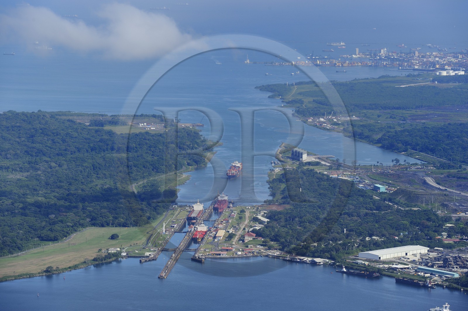 Panama, province de Colon, Canal de Panama, cargo Panamax passant les écluses de Gatun, la baie Limon (Bahia Limon) coté Atlantique et la ville de Colon en arrière plan (vue aérienne)