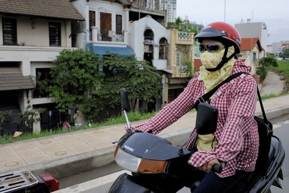 Vietnam, Hanoï, circulation en moto dans la vieille ville, emmitouflage contre le soleil par 35° et protection contre la pollution