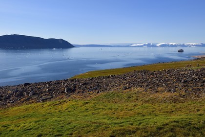 Groenland, cote Nord-Ouest, Murchison sound au nord de la baie de Baffin, randonneurs dans le fjord Robertson à Siorapaluk qui est le village le plus septentrional du Groenland, le bateau de croisière MS Fram de la compagnie Hurtigruten au mouillage en arrière plan