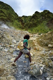Caribbean, Dominica Island, Castle Bruce, Morne Trois Pitons National Park listed as World heritage by UNESCO, Valley of Desolation, hiker crossing a river of hot springs, whose unique color is due to the presence of calcium, carbon, sulfur and iron, on the trail leading to Boiling Lake
